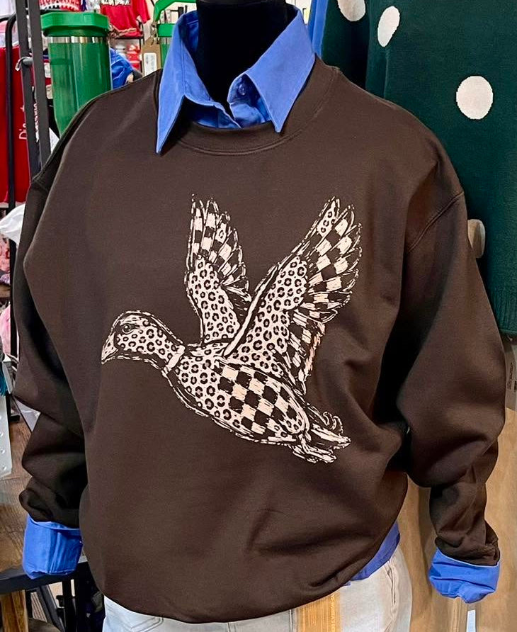 leopard and check designed flying mallard duck on a dark brown sweatshirt. being worn on a mannequin and a blue button up shirt underneath the sweatshirt