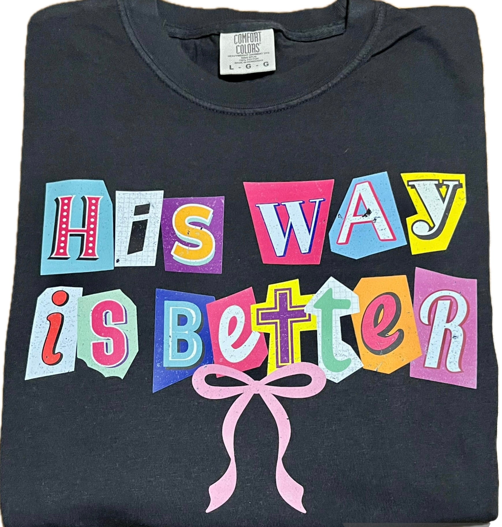 Black t-shirt with colorful text 'His Way is Better' and a pink bow on a white background