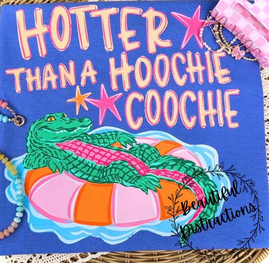 blue short sleeve teewith a cartoon alligator on an inner tube, text 'Hotter Than A Hoochie Coochie', and 'Beautiful Distractions' branding.