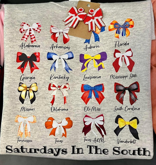 A gray crewneck sweatshirt with a pattern of various colored bows and text representing different states in the South, with the text 'Saturdays in the South' at the bottom.