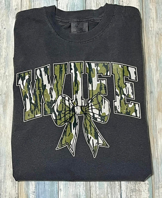 A  pepper color t-shirt with camouflage print and the text 'WIFE' in bold letters, featuring a cute bow design.