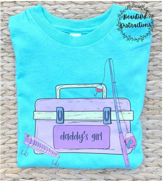 mint color t-shirt with a purple and pink fishing tackle box graphic and 'daddy's girl' text on a woven surface.