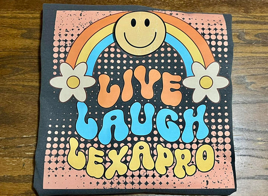 Decorative short sleeved tee with a smiley face, rainbow, flowers, and 'live Laugh Lexapro' decal